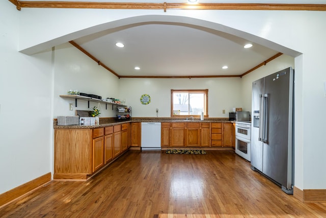 kitchen with open shelves, dark wood-style floors, white appliances, arched walkways, and brown cabinetry