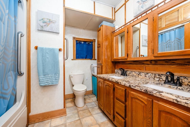 bathroom with a sink, toilet, and double vanity