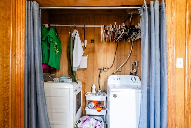 laundry area with washer and dryer, laundry area, and wood walls