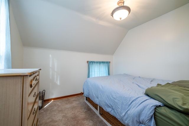 carpeted bedroom with baseboards and lofted ceiling