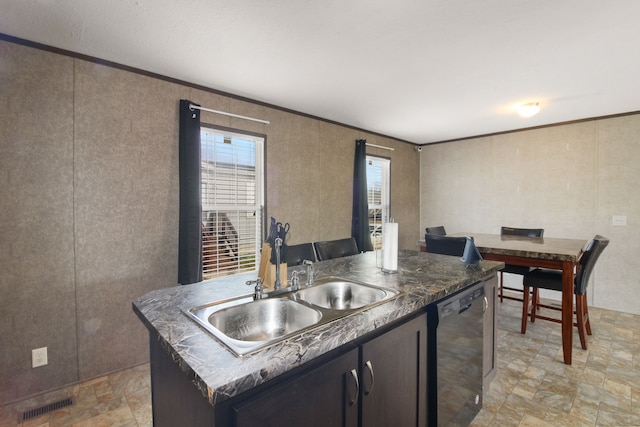 kitchen with visible vents, an island with sink, a sink, dark countertops, and dishwashing machine