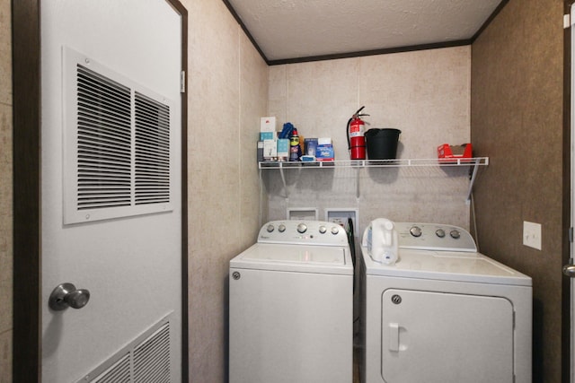 laundry area with laundry area, independent washer and dryer, and a textured ceiling