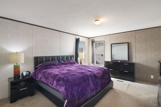 carpeted bedroom featuring visible vents, a textured ceiling, and ornamental molding