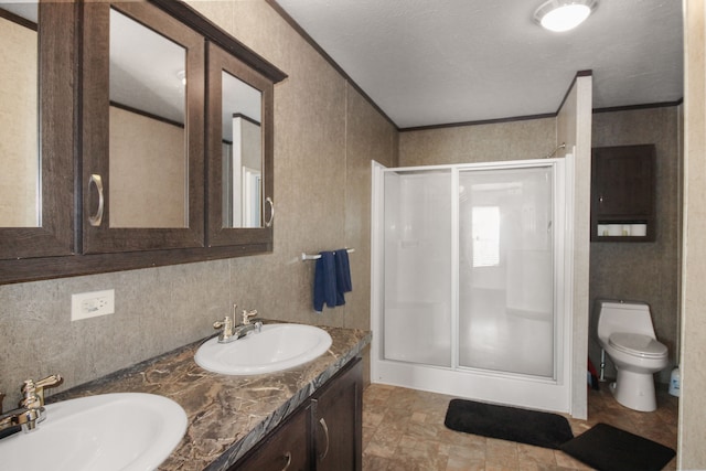 full bath with double vanity, ornamental molding, a stall shower, and a sink