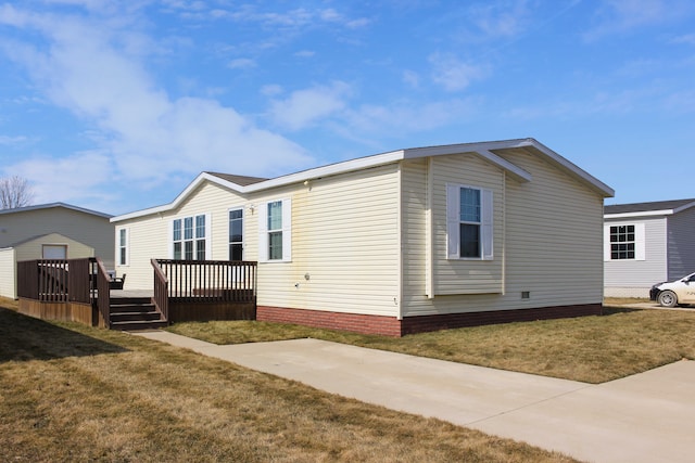 view of side of home with a lawn and a wooden deck