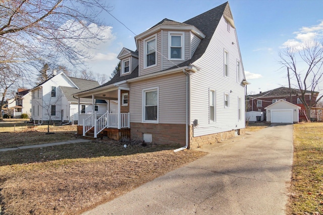 view of front facade featuring an outbuilding, driveway, a porch, a shingled roof, and a garage