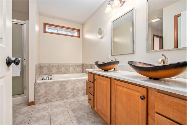 bathroom with tile patterned floors, double vanity, a stall shower, a bath, and a sink