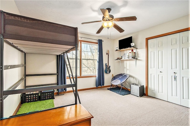 bedroom with a closet, carpet flooring, ceiling fan, and baseboards