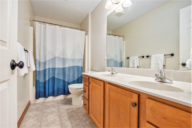 bathroom featuring tile patterned flooring, toilet, visible vents, and a sink