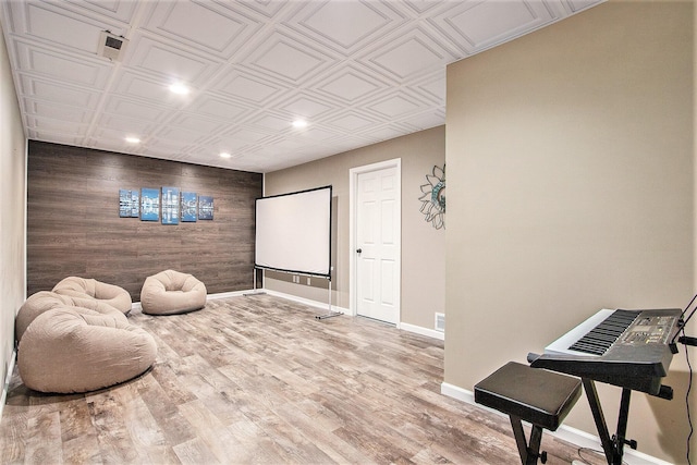 interior space featuring wood finished floors, baseboards, recessed lighting, an ornate ceiling, and wood walls