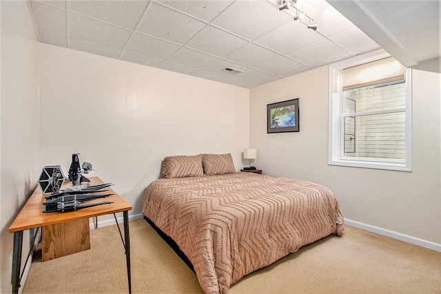 bedroom featuring carpet flooring, a paneled ceiling, and baseboards