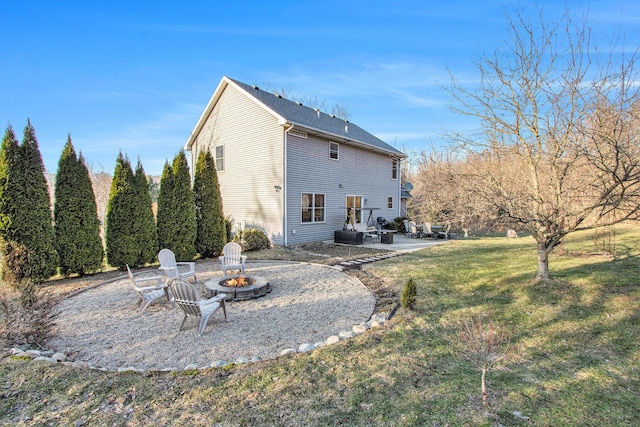 rear view of property with a yard, a patio, and a fire pit