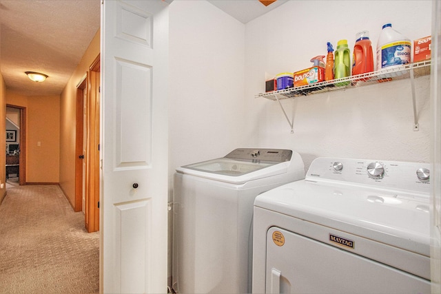 laundry area with a textured ceiling, laundry area, independent washer and dryer, and light carpet