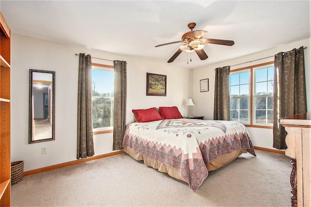 bedroom with baseboards, multiple windows, a ceiling fan, and carpet flooring