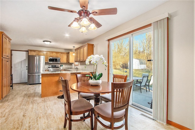 dining area with visible vents, a ceiling fan, and light wood finished floors