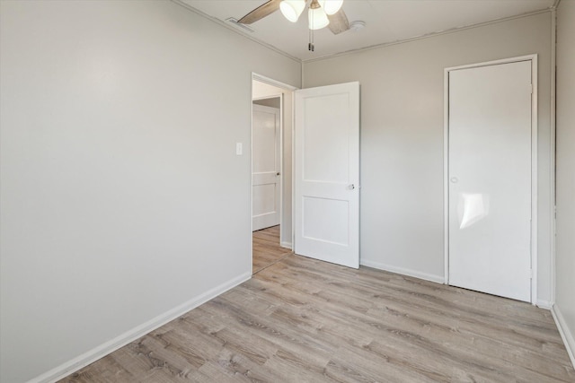 unfurnished bedroom featuring baseboards, light wood-style floors, and a ceiling fan