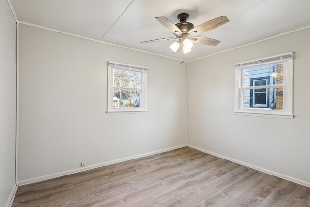 empty room with a ceiling fan, light wood-style floors, and baseboards