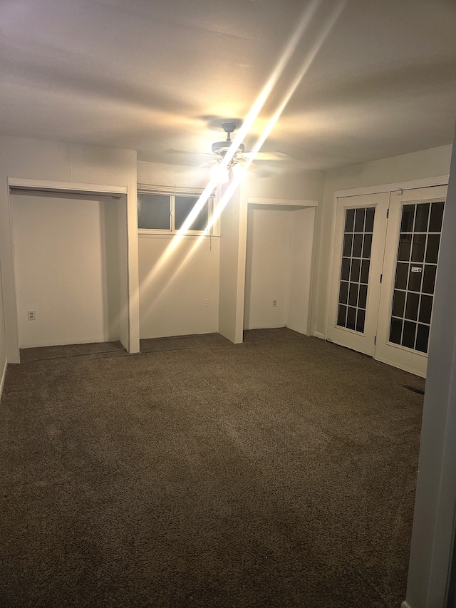 empty room with dark carpet and ceiling fan