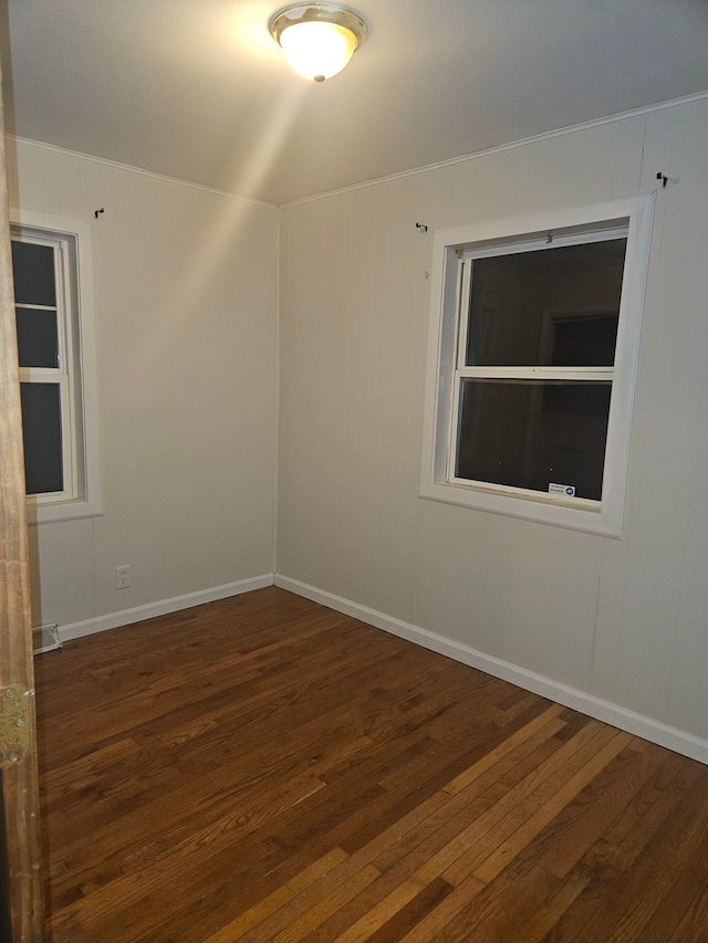 spare room featuring visible vents, wood-type flooring, and baseboards