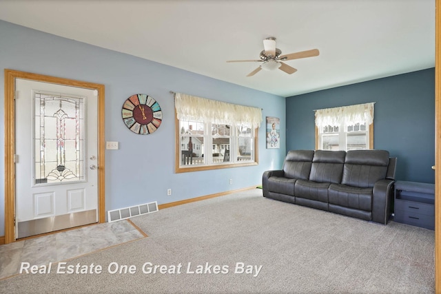 living room with a ceiling fan, carpet, visible vents, and baseboards