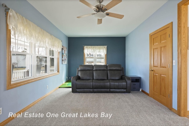 living area featuring baseboards, carpet floors, and ceiling fan