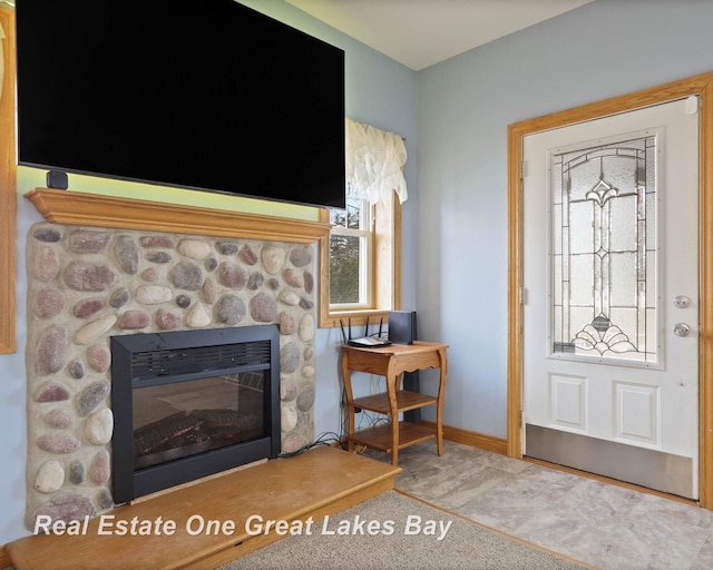 foyer with a stone fireplace and baseboards