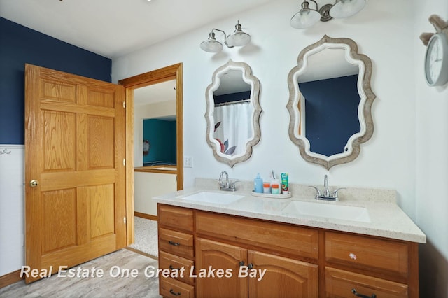 full bathroom with a sink and double vanity