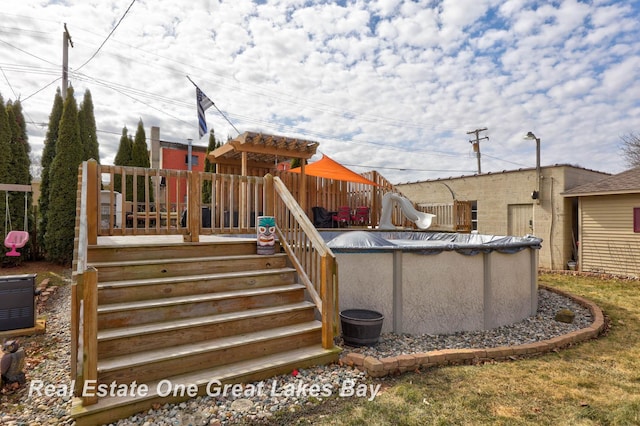 exterior space featuring a covered pool, a water slide, and a deck