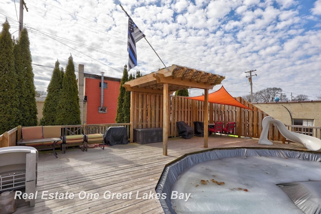 wooden terrace featuring an outdoor hangout area and fence