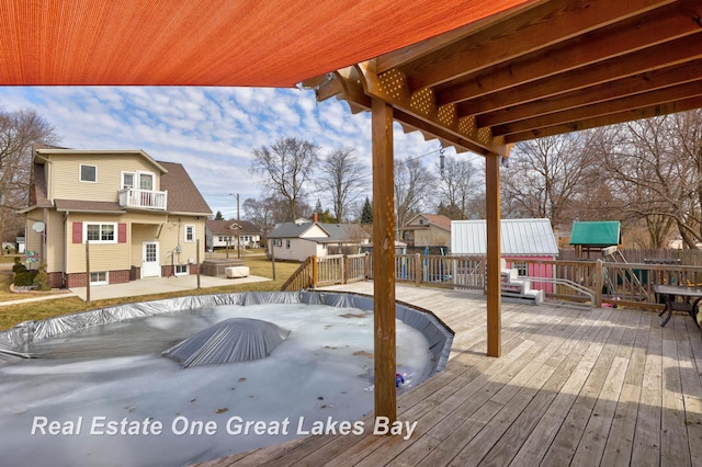 wooden terrace with fence, a patio area, and a residential view