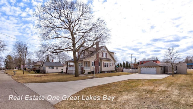 view of front of house featuring a residential view, concrete driveway, a chimney, and a front yard