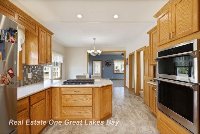 kitchen featuring a notable chandelier, tasteful backsplash, recessed lighting, stainless steel appliances, and a peninsula