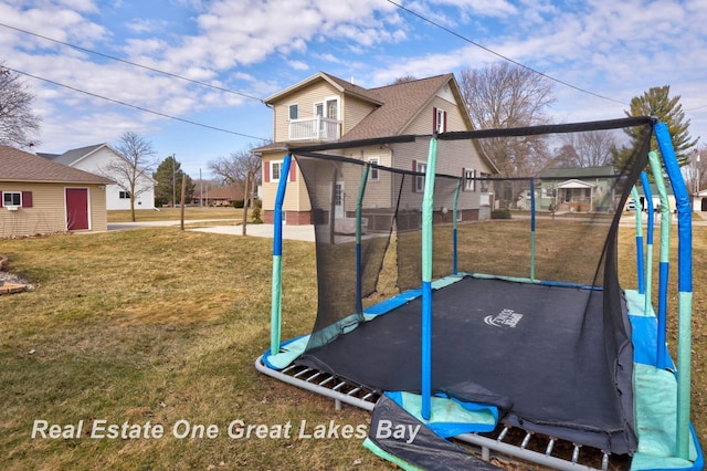 view of jungle gym with a trampoline and a yard