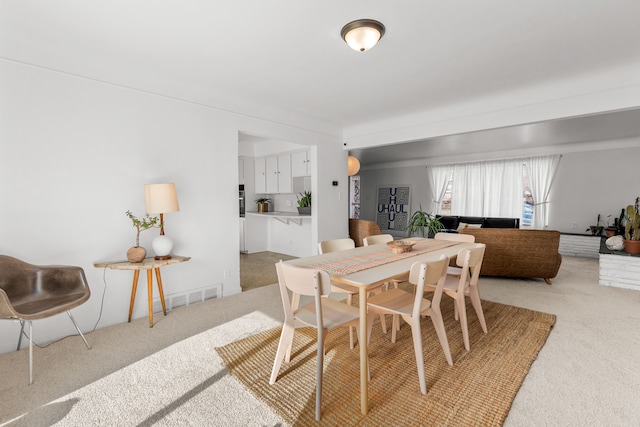 dining space featuring light colored carpet and visible vents