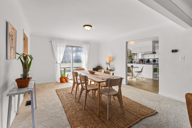 dining room with baseboards, visible vents, and light carpet