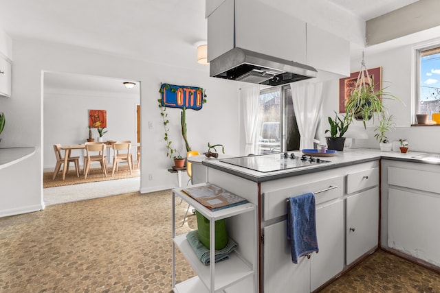 kitchen featuring black electric stovetop, exhaust hood, white cabinets, light countertops, and baseboards