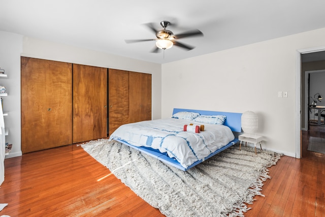 bedroom featuring baseboards, a closet, wood-type flooring, and ceiling fan