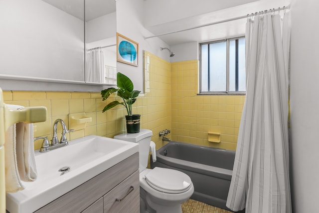 bathroom featuring toilet, vanity, tile walls, and shower / bath combo with shower curtain