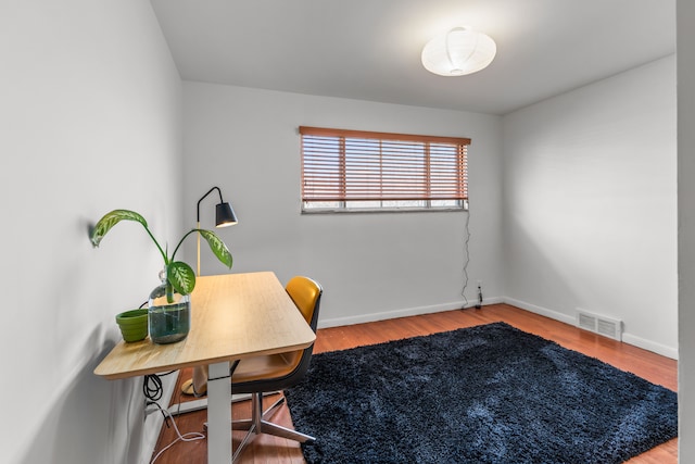 office space with visible vents, baseboards, and wood finished floors