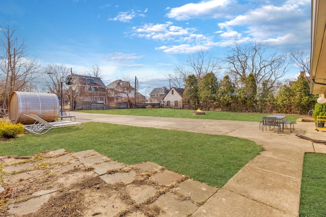 view of yard with a patio, fence, an outdoor structure, a greenhouse, and a residential view