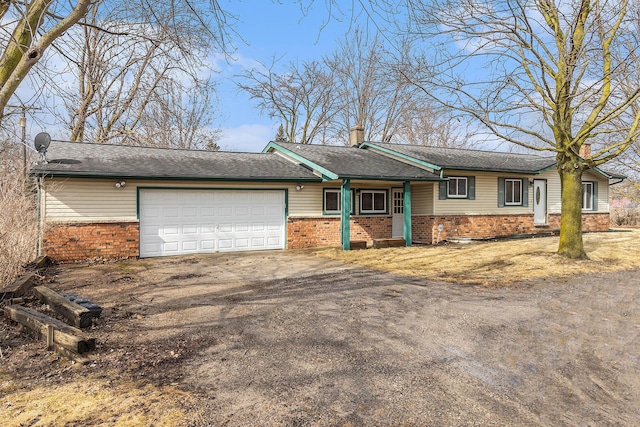 view of front of property featuring driveway, roof with shingles, an attached garage, brick siding, and a chimney