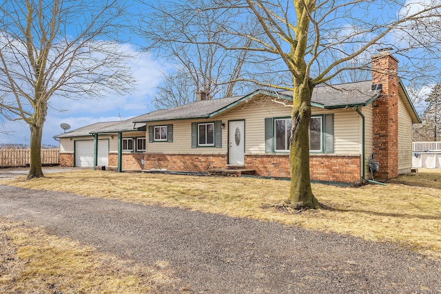 single story home with brick siding, fence, a chimney, driveway, and an attached garage