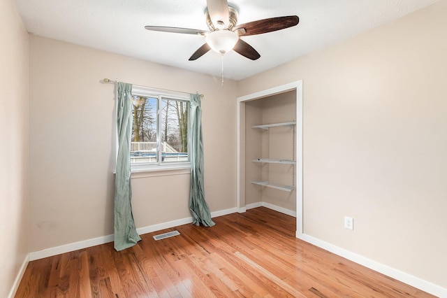 unfurnished bedroom featuring visible vents, baseboards, light wood-style flooring, and a ceiling fan