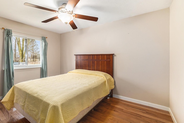 bedroom featuring a ceiling fan, baseboards, and wood finished floors