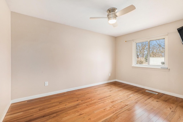 spare room with ceiling fan, baseboards, visible vents, and light wood-type flooring