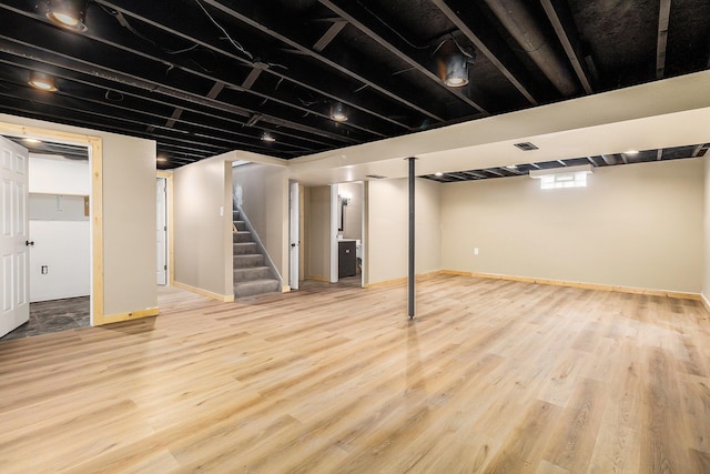 below grade area with stairway, baseboards, and wood finished floors