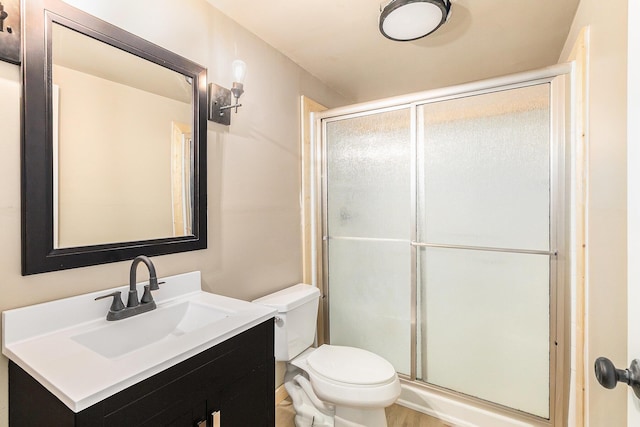 full bathroom with a stall shower, toilet, and vanity