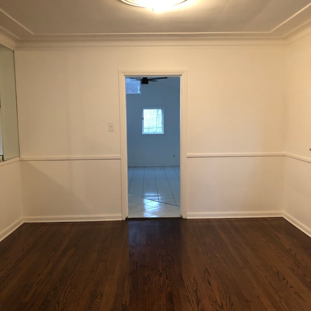 unfurnished room with wood finished floors, baseboards, and ornamental molding