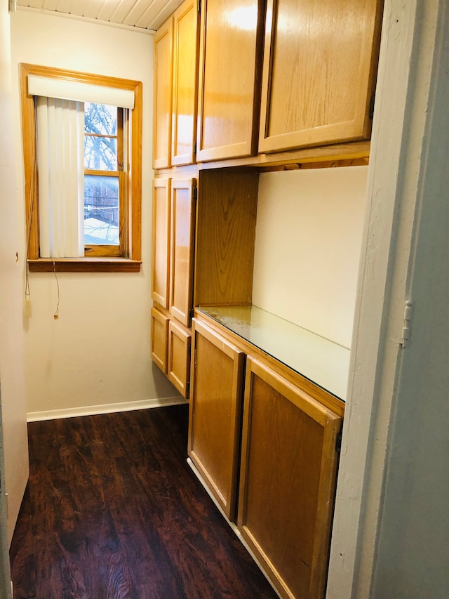 interior space featuring baseboards and wood finished floors