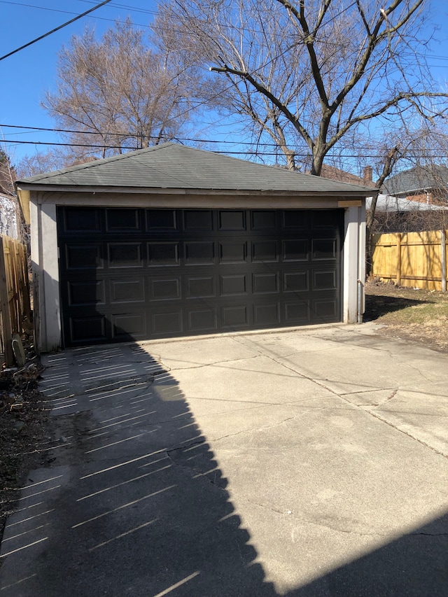 detached garage featuring fence